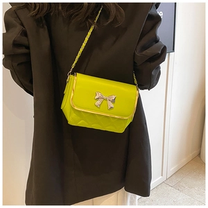 Detailed view of neon green crossbody bag featuring a silver butterfly buckle and chain