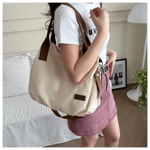 Canvas tote bag in beige and brown shown on model for casual commuting use