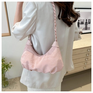 Side view of a pink pleated dumpling bag with braided shoulder strap on model