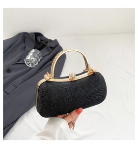 Detailed view of the rhinestone handle and shimmering black glitter on the evening bag