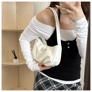 Close-up of white leather crescent bag with silver butterfly buckle detail