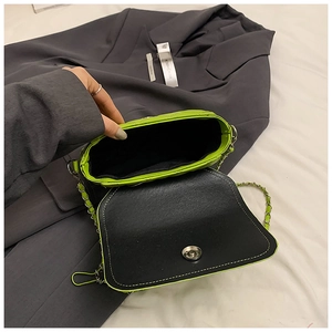 Detail view of neon green patent leather bag interior with chain strap and magnetic closure