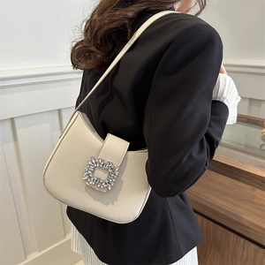 Chic beige underarm bag with sparkling crystal buckle shown on a model's shoulder