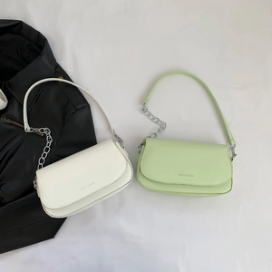 Minimalist faux leather saddle bags in beige and light green with silver chain detail