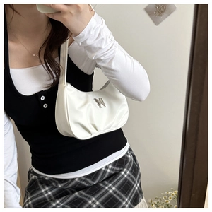 Close-up of white pleated hobo bag with a silver butterfly metal detail on PU leather
