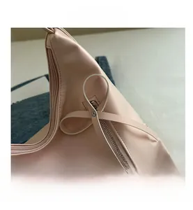 Detailed macro view of pink tote bag featuring PU leather texture and bow ornament