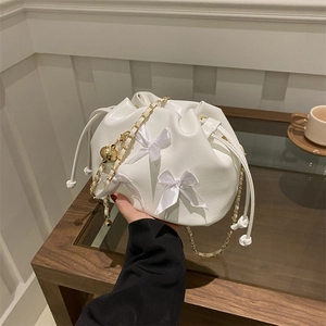 White pleated drawstring bucket bag with satin bows and golden chain strap for women