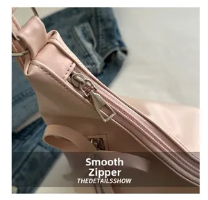 Detail shot of smooth silver zipper closure on pink faux leather tote bag with metallic hardware
