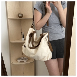 Detailansicht der cremeweißen Canvas-Tasche mit braunen Trägern im Lifestyle-Ambiente