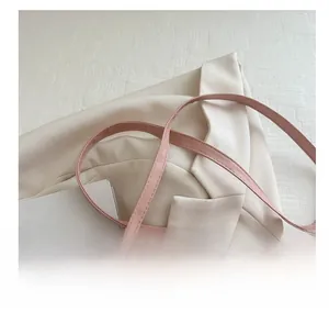 Dettaglio della tracolla in pelle regolabile con cuciture fini su una borsa rosa tenue