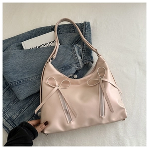 Détail du sac hobo en cuir PU rose avec nœuds décoratifs et doubles fermetures éclair