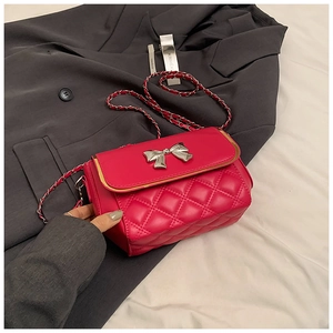 Detail view of the rose red quilted crossbody bag with silver butterfly buckle