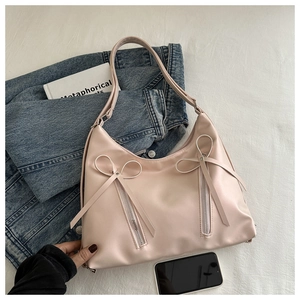 Detailed view of the light pink tote bag featuring dual bows and silver zipper accents
