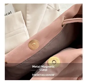 Dettaglio borsa a secchiello rosa chiaro con due fibbie magnetiche dorate circolari
