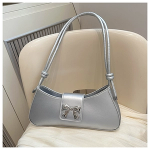 Detail of silver baguette bag with metallic leather finish and bow-knot closure