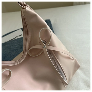 Détail du sac en cuir PU rose avec un nœud 3D élégant et une fermeture éclair argentée brillante