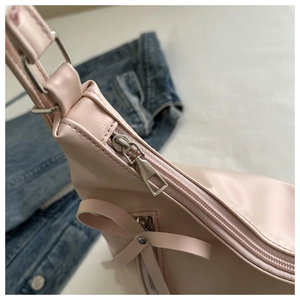 Gros plan d'un sac cabas en cuir PU rose avec nœud élégant et fermeture argentée