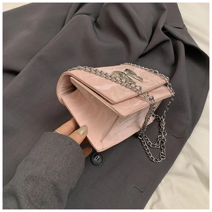Vue latérale du sac en cuir verni rose avec nœud argenté et structure en accordéon