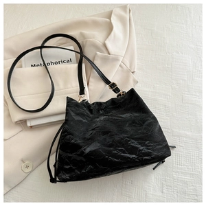 Dettaglio della borsa hobo nera con trama in pelle increspata e fibbia in metallo oro