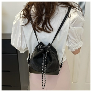 Detail showing back view of black leather bucket backpack with decorative metal chain detail