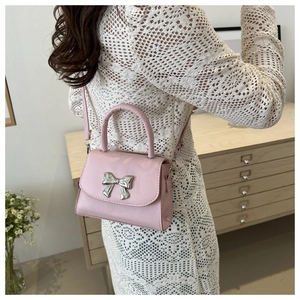 Vista dettagliata posteriore di una borsa rosa mini con fiocco argento e manico