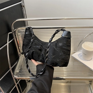 Ruched black dumpling shoulder bag with woven strap and trendy crescent moon shape design