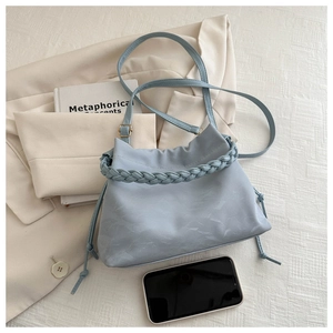 Dettaglio borsa shopper azzurra con manico intrecciato e coulisse su tessuto a trama