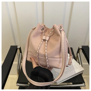 Close-up of pink leather bucket bag with silver chain drawstring and fashion text detail