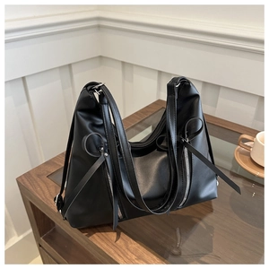 Détail du sac hobo en cuir PU noir avec fermetures éclair argentées et rubans