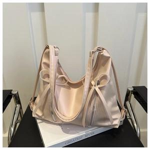 Détail d'un sac cabas blanc crème avec des nœuds élégants et des accents de zip en métal
