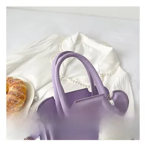 Detail of purple leather handbag featuring wavy edges and a white plush cloud charm