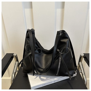 Détail du sac cabas en cuir PU noir avec grand nœud et fermetures éclair argentées