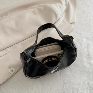 Black crescent hobo bag with silver butterfly buckle showing interior storage capacity