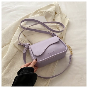 Dettaglio della borsa a tracolla viola in finta pelle con design a onde e catena oro