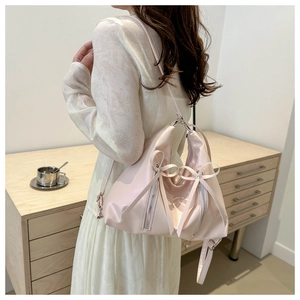 Gros plan du sac à dos rose à nœuds sur modèle montrant le cuir synthétique et les zips