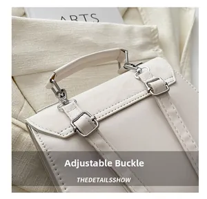 Detail of adjustable silver buckle and lychee leather texture on a cream beige backpack
