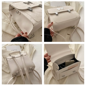 Close-up of cream butterfly mini backpack with embossed texture and metal clasp