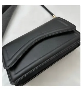 Detail view of the black quilted rectangular flap bag with elegant gold-tone metal hardware
