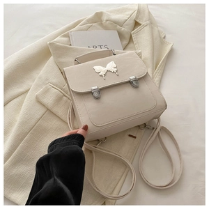 Close-up of cream PU leather backpack featuring a silver butterfly clasp and flap closure