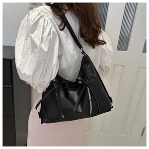 Détail du sac cabas en PU noir avec nœuds et fermetures éclair métalliques sur mannequin