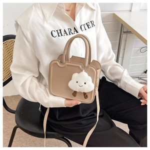 Beige minimalist crossbody bag detail featuring a cute white plush cloud charm accessory