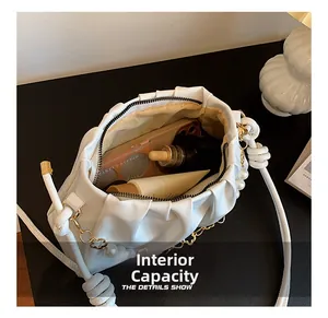 Top view of white ruched cloud bag showing large interior capacity with makeup and phone