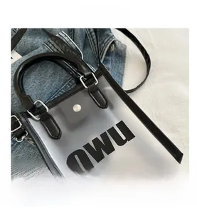 Détail du sac gelée givré translucide avec logo OWU noir et bandoulière en cuir