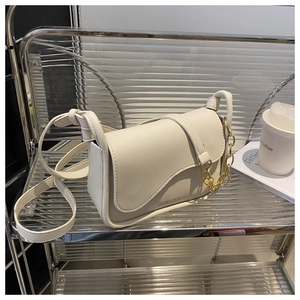 Dettaglio borsa a tracolla in pelle PU beige con catena dorata e texture minimalista