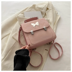Detailed view of pink backpack with silver butterfly hardware and dual buckle closure