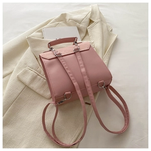 Detailed close-up of a pink mini PU leather backpack with silver metallic buckles