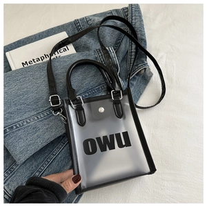 Détail du sac gelée givré transparent avec logo OWU noir sur une veste en jean bleu