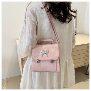Pink glossy patent leather crossbody bag with silver butterfly metal ornament detail