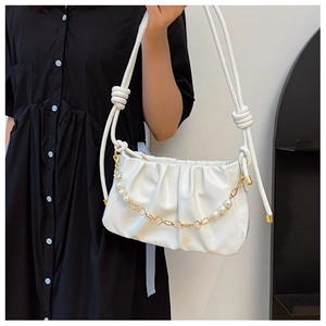 Detail of white pleated cloud bag with elegant pearl chain and knotted shoulder strap