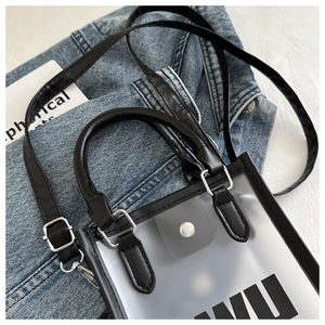 Détail d'un mini sac givré translucide avec bordure noire sur fond en denim